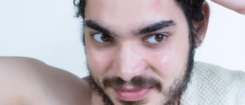 [freepicdownloader.com]-caucasian-young-man-with-brown-eyes-beard-combing-his-hair-while-standing-bathroom-large